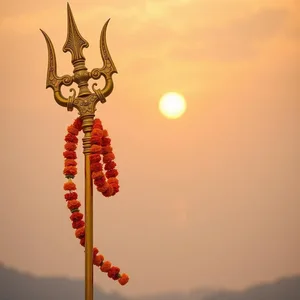 radiant good morning durga images wishes wallpaper: ornate golden trident with marigold garlands at sunrise